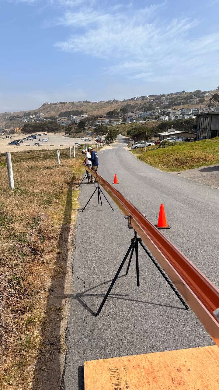 Long copper gutter run staged on tripod stands coastal California job site