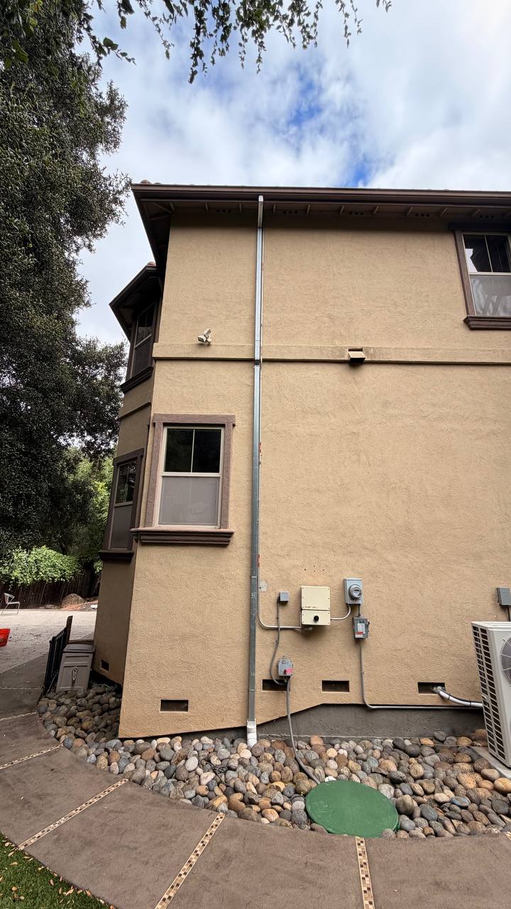 Downspout install stucco bay window red deck railing