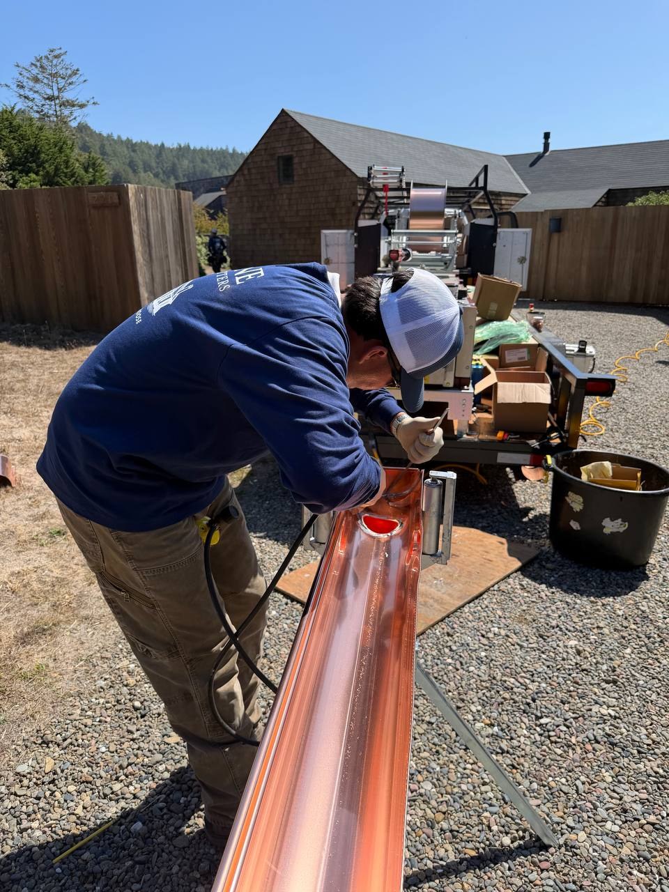 Worker fitting a copper gutter outlet