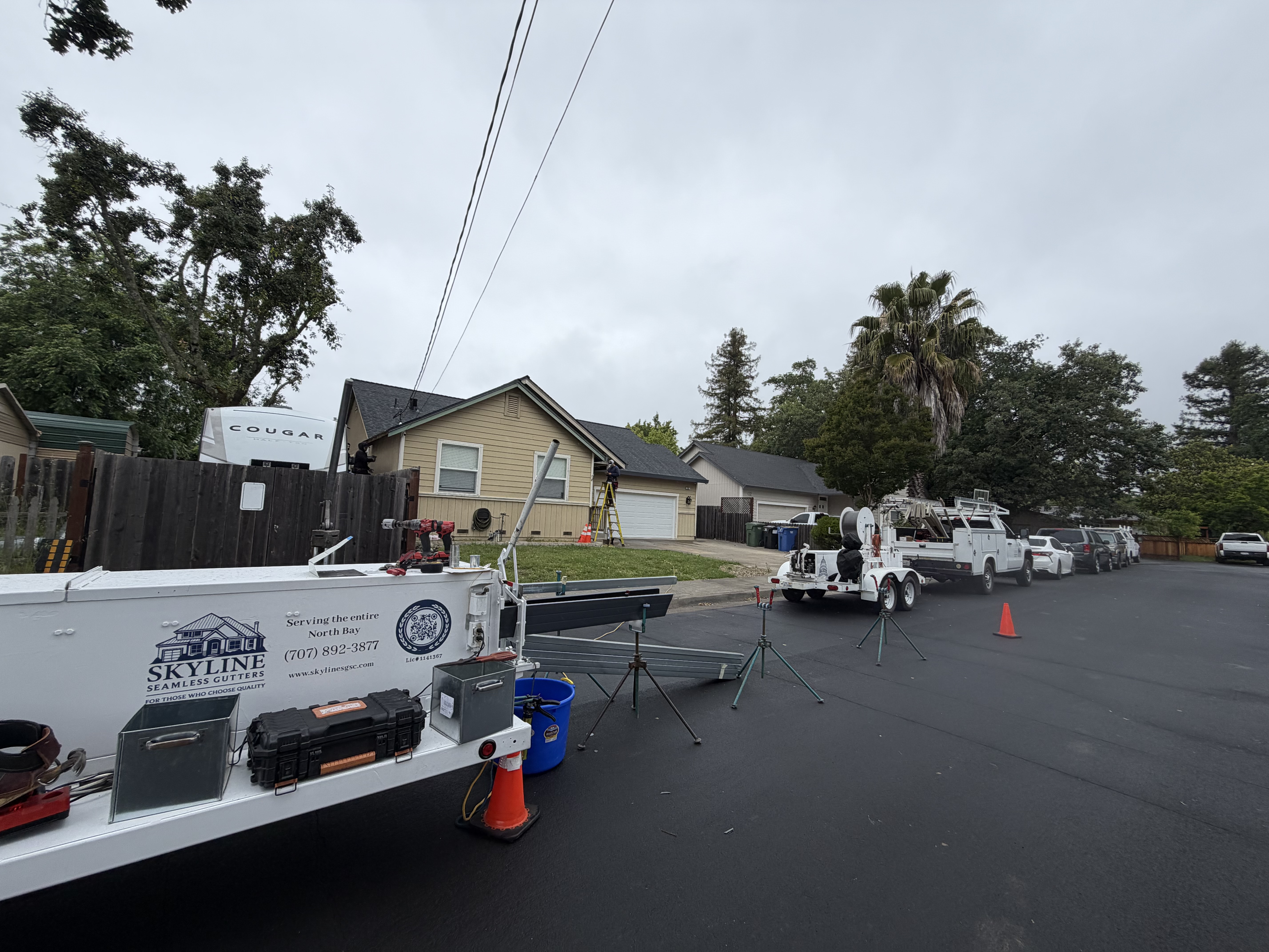 Skyline Seamless Gutters truck and forming machine on residential job site